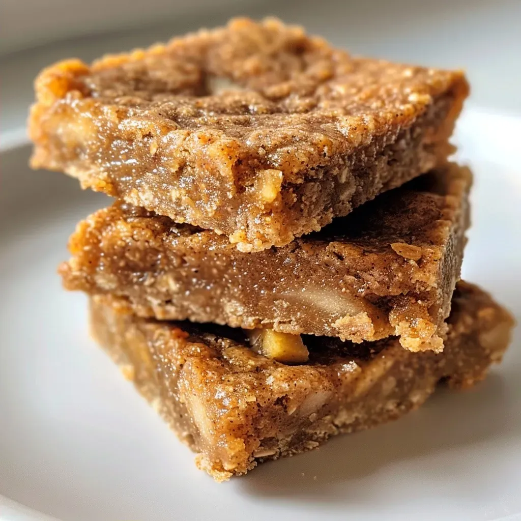 ['Close-up side view of a stack of Apple Protein Bars with a textured surface.', 'Juicy Apple Protein Bars arranged on a wooden board, showcasing their ingredients.', 'Detailed side view of a freshly made Apple Protein Bar, highlighting its chewy texture.', 'A vibrant Apple Protein Bar surrounded by ingredients like apples and spices.']