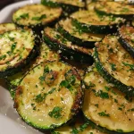 ['Close-up view of baked zucchini slices, golden brown with a sprinkle of cheese and herbs.', 'Side perspective of juicy baked zucchini, showcasing its tender texture and garnished with parsley.', 'Deliciously baked zucchini rounds, lightly crisped and topped with parmesan and herbs.', 'Freshly baked zucchini slices arranged on a plate, glistening with olive oil and spices.']