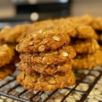 ['A close-up side view of healthier pumpkin spice cookies on a plate.', 'Juicy pumpkin spice cookies with a golden-brown color, displayed on a wooden table.', 'A detailed look at freshly baked pumpkin spice cookies topped with powdered sugar.', 'An intimate side angle of soft pumpkin cookies showcasing their texture and color.']