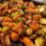 ['Close-up side view of roasted Brussels sprouts and carrots glazed with maple syrup.', 'Juicy maple glazed vegetables including Brussels sprouts and small carrots on a plate.', 'Colorful assortment of roasted vegetables, featuring shiny maple glaze, highlighting Brussels sprouts and carrots.', 'Side view of succulent roasted vegetables, showcasing the caramelized texture from maple syrup.']