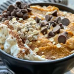 ['A close-up view of a pumpkin spice yogurt bowl with chocolate chips and a drizzle of magic shell.', 'Side view of a creamy yogurt bowl topped with pumpkin puree, spices, and chocolate treats.', 'Delicious-looking pumpkin spice yogurt bowl with a glossy chocolate shell and vibrant colors.', 'A tantalizing yogurt bowl featuring pumpkin flavors, chocolate chips, and a shiny topping.']