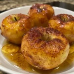 Close-up side view of air-fried apples, glistening with a cinnamon glaze.