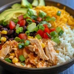 Close-up view of a colorful Crock Pot Chicken Burrito Bowl with chicken, beans, corn, and avocado.