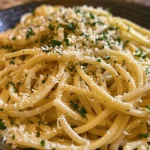 Close-up of creamy garlic butter pasta with spaghetti and parsley.