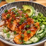 A close-up side view of a colorful salmon rice bowl filled with fresh ingredients.