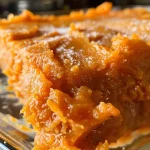 Close-up view of a fluffy sweet potato dish topped with a golden brown layer of marshmallow cream.