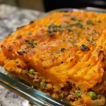 Close-up side view of a vibrant Sweet Potato Shepherd's Pie featuring a golden crust.